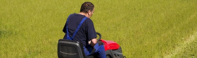 man mowing the lawn with a riding lawn mower