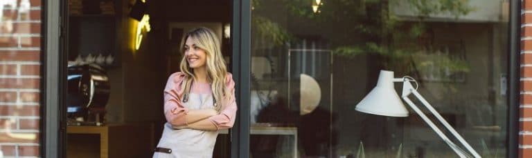 woman standing at the door of a restaurant