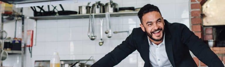 man smiling in a restaurant kitchen