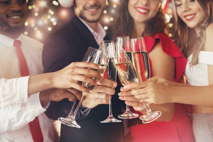 Holiday party guests toasting with champagne.