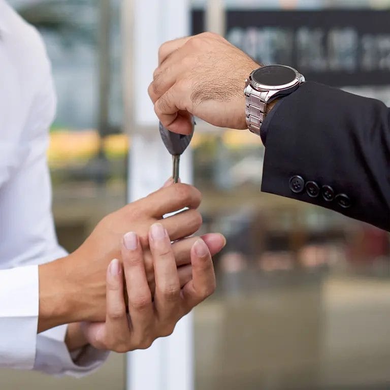 Close-up of a man passing his car keys to a valet.