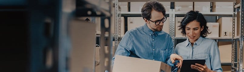 man and woman reviewing products in warehouse