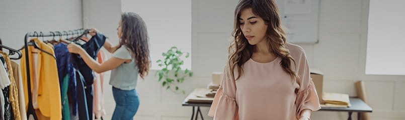 two woman setting up retail space