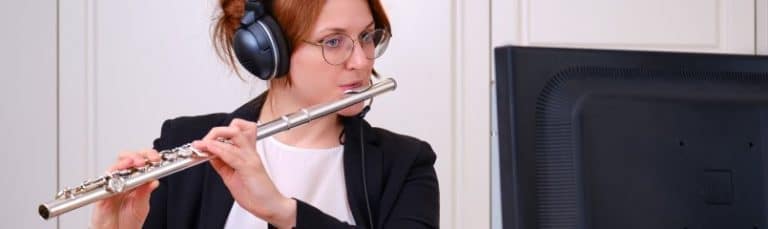 woman playing the flute to online class