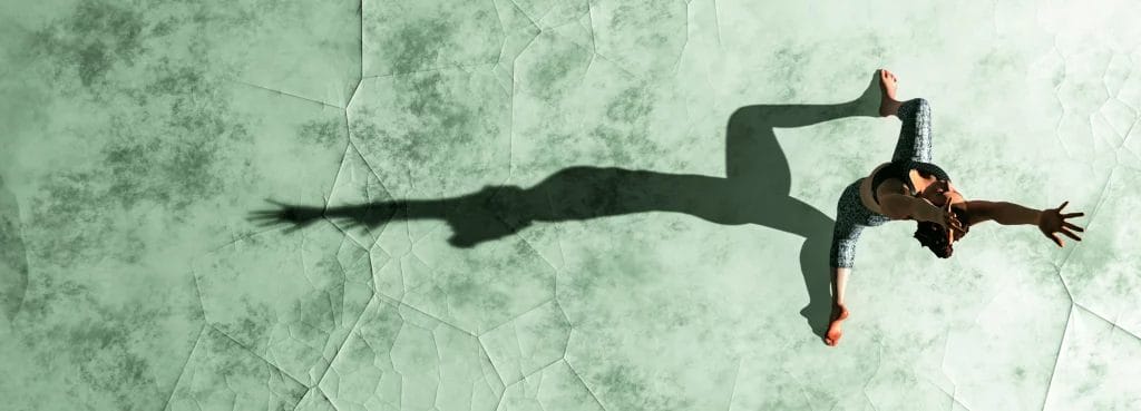 A yoga instructor poses on a green glass outdoor surface