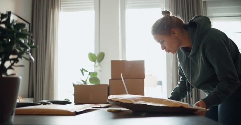 a woman packages merchandise for her amazon store.