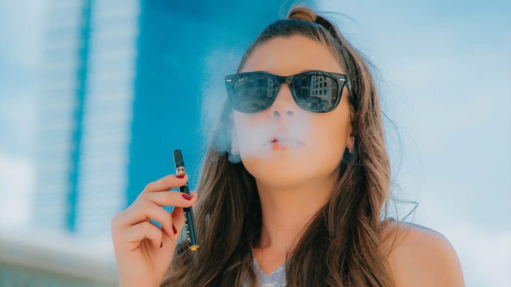 A woman vapes a THC wax pen.