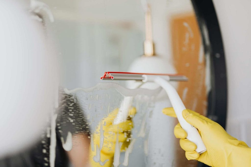 maid cleaning mirror