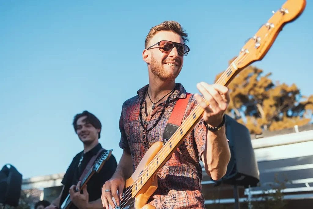 Band members playing guitars outside.