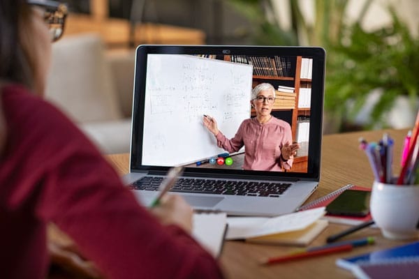 student taking notes during virtual class