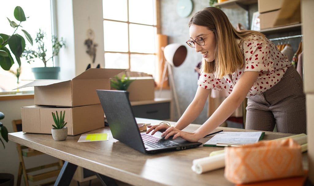 An eBay seller is buying eBay liability insurance from her computer in her home office where she manages her eBay business.