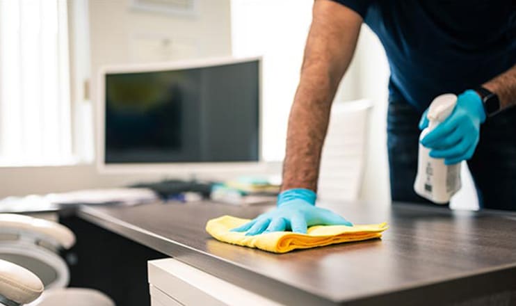 cleaner scrubbing down desk