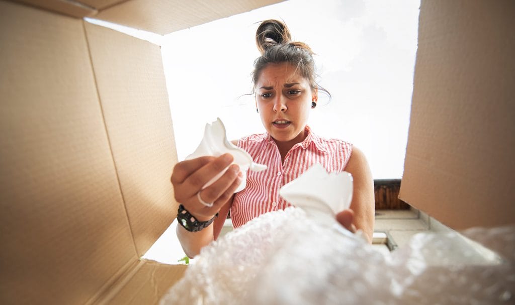 woman opening package of broken product