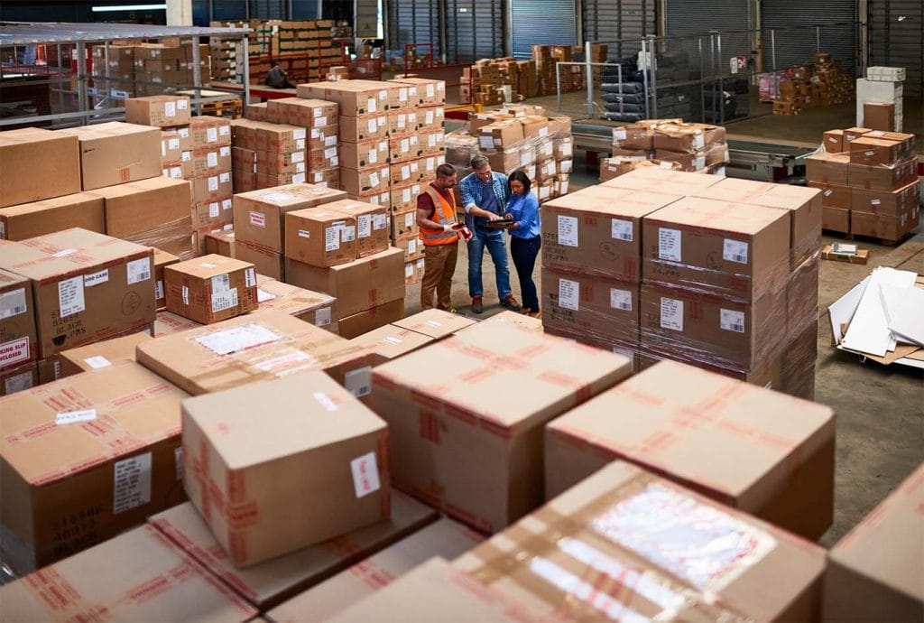 Boxes stacked in a warehouse full of products insured with product liability insurance from insurance canopy.