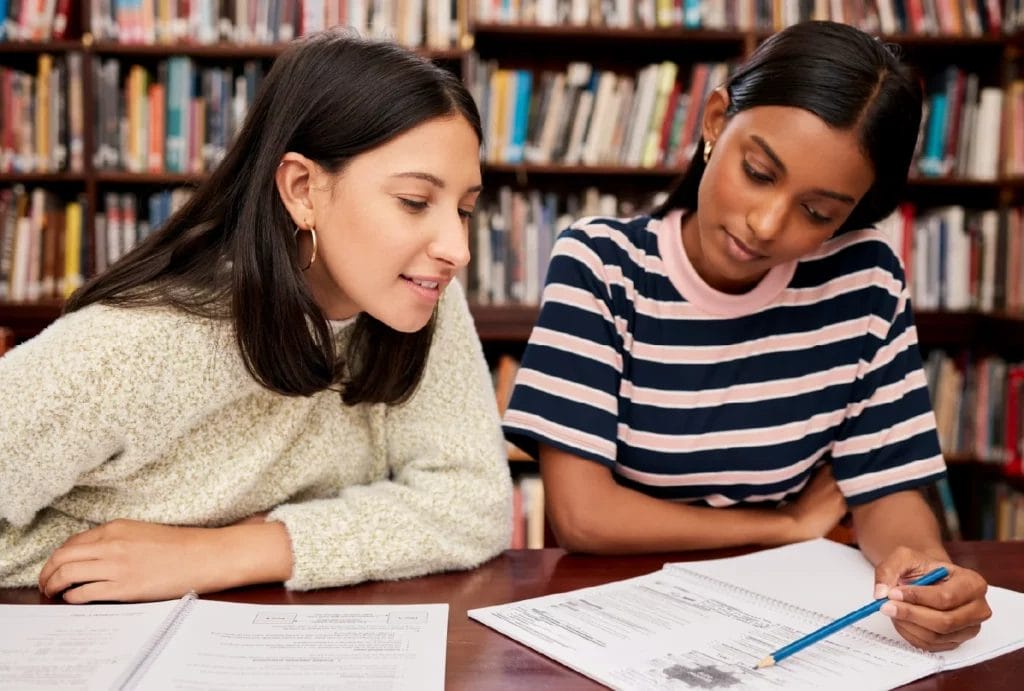 Tutor working with student in library