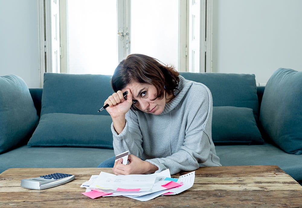 A frustrated business owner with papers on their desk.