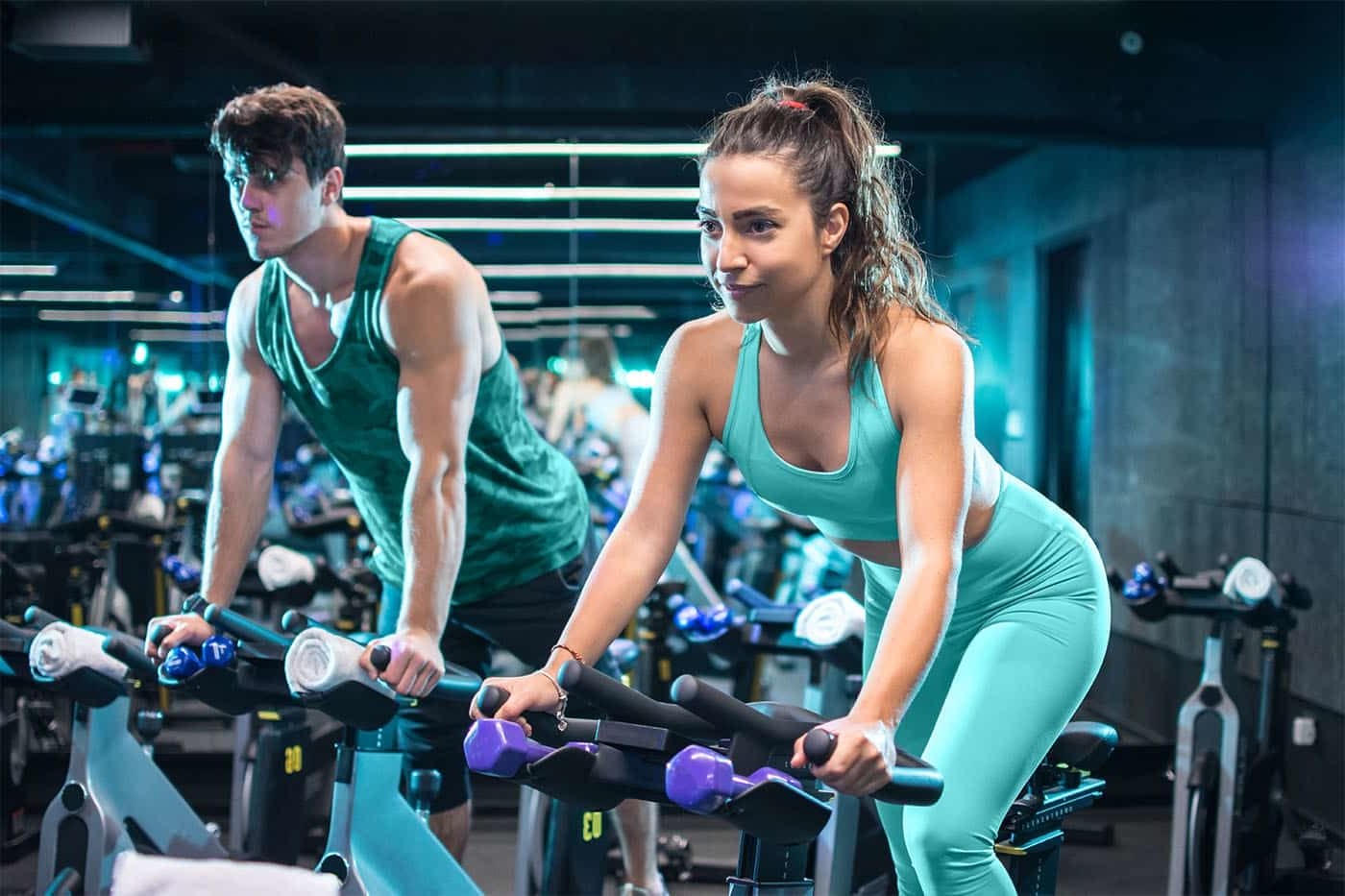 Two spin classmates work hard in a spin class.