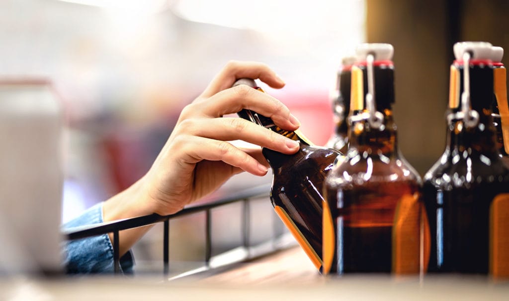 A hand is pulling a product off of a shelf.