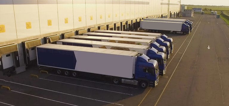 A row of trucks in a loading dock for importing.