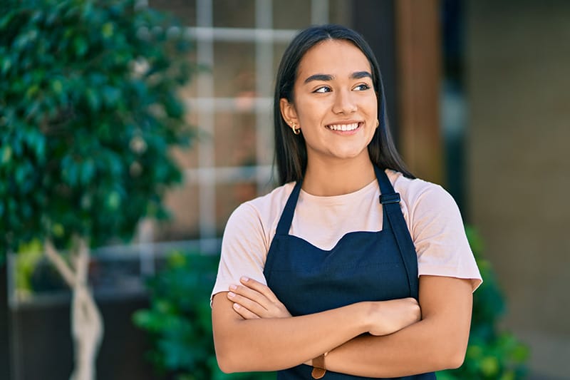 A business owner stands outside of her building insured with general liability insurance.