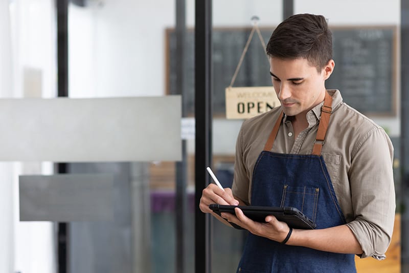 A business owner works on a tablet.