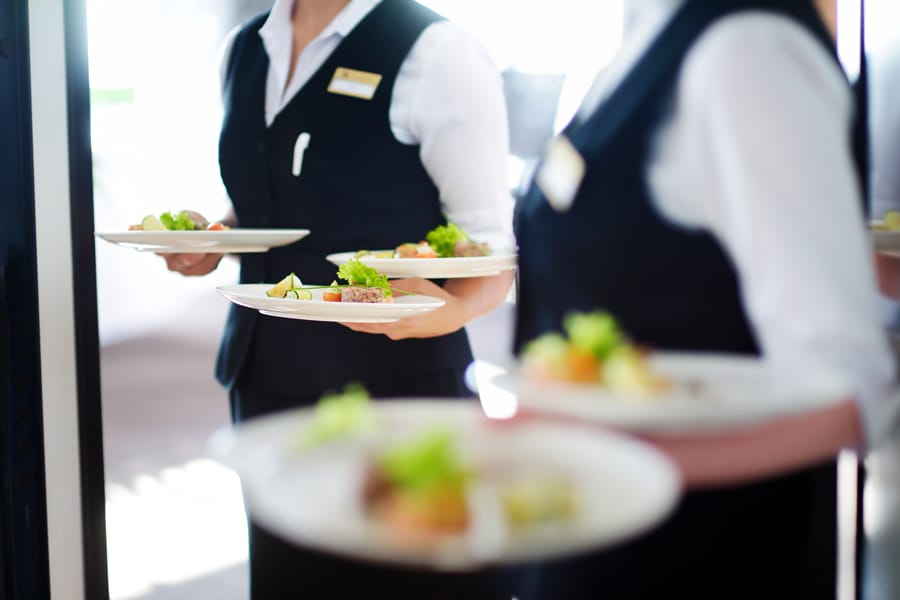 Catering servers with platters of food