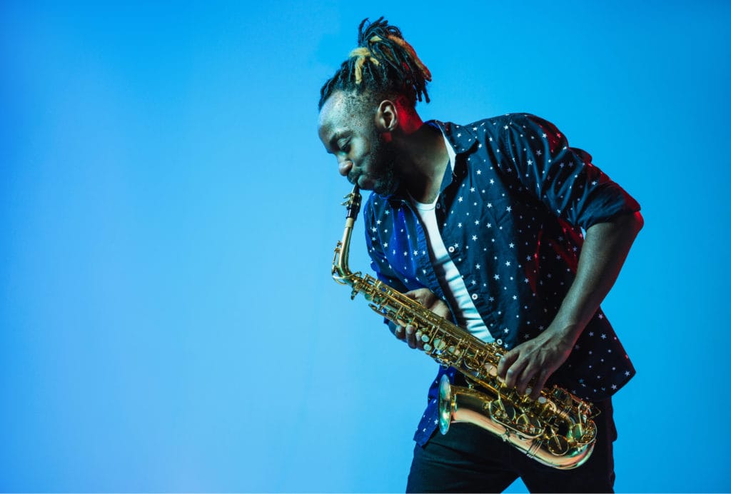 Musician with a saxophone on a blue background.