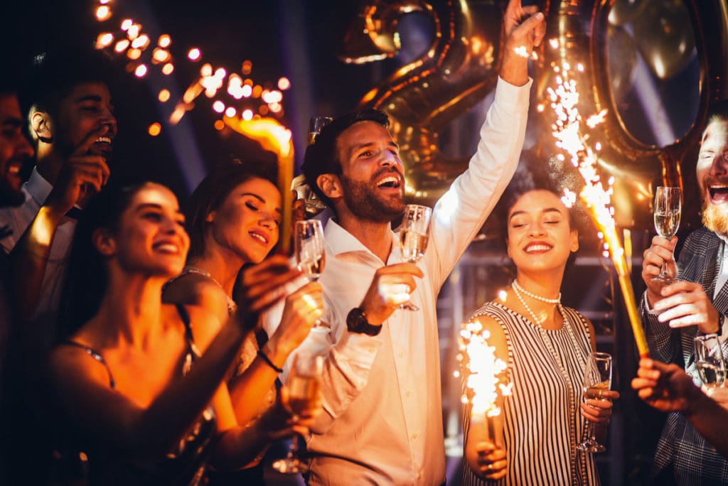 Group celebrating the new year with drinks and sparklers