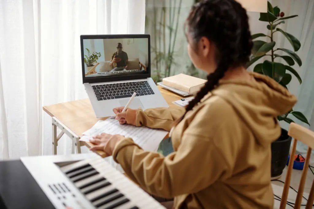 Young girl learning from tutor via virtual lesson