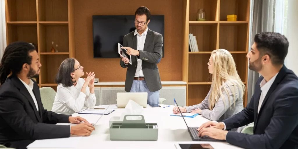 Group setting where an instructor is going over key material on a tablet.