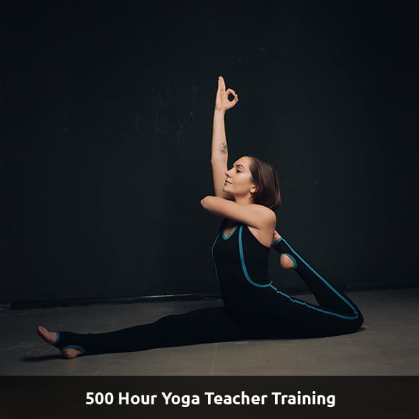 A yoga instructor sits in a splits position. Text reads: 500 Hour Yoga Teacher Training.