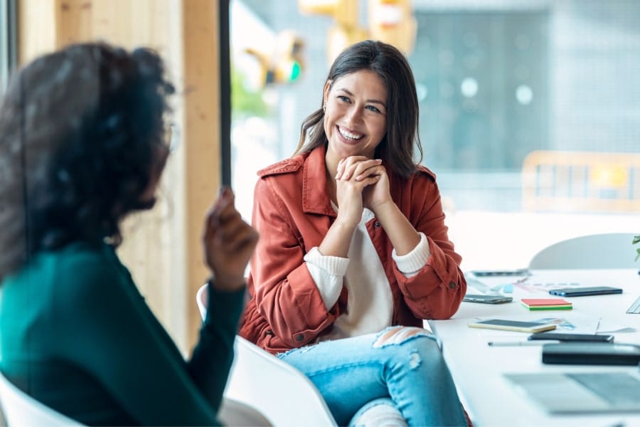 two women having an enjoyable conversation sitting across from each other