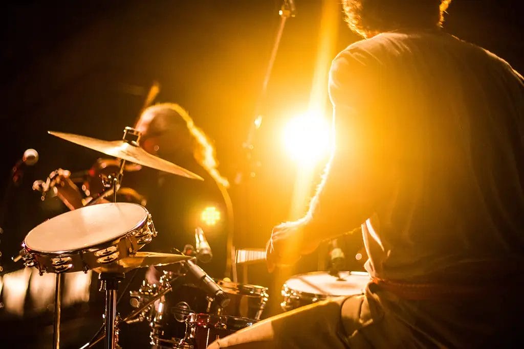 Drummer on stage with bright lights