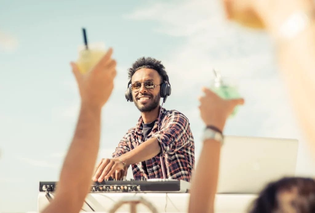 A DJ mixing at a beach party