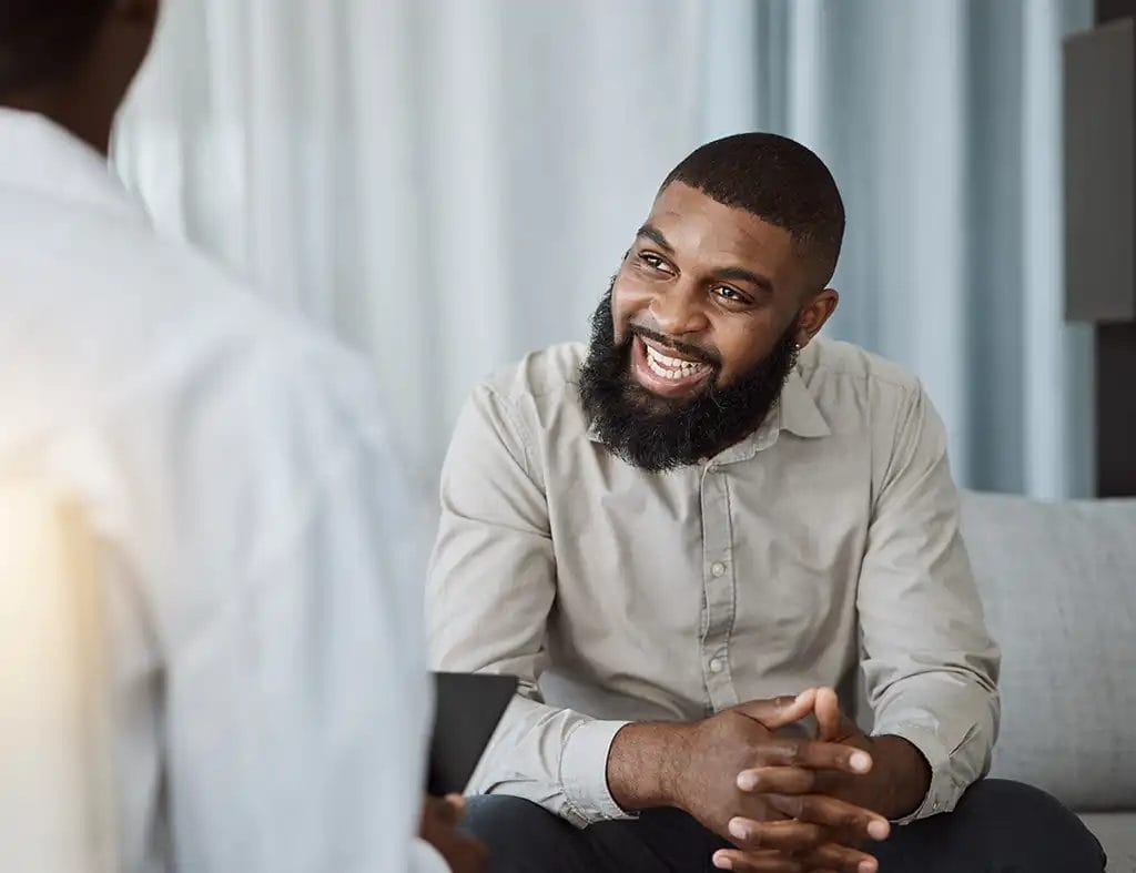 Man sitting on a couch across from a life coach