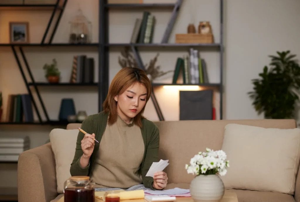 A person sitting on a couch with a pen and study cards