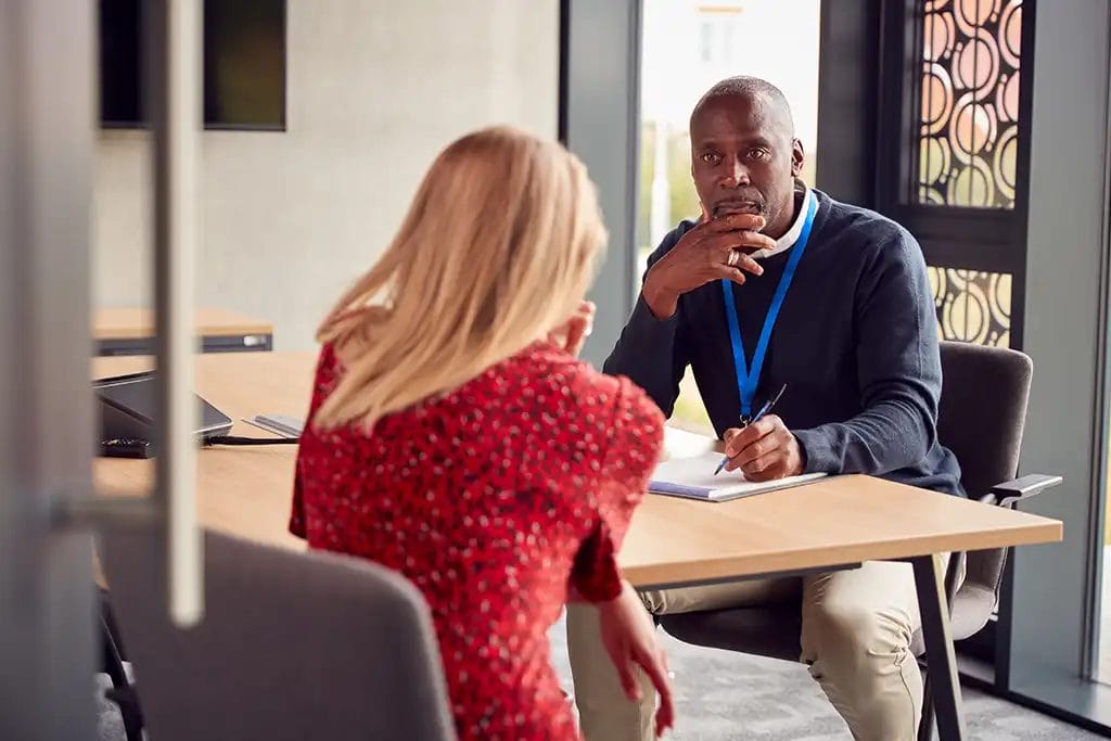 Two people sitting across from each other in a meeting.