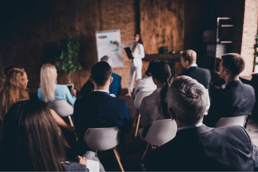 Room of businesspeople listening to a presentation in a business meeting.