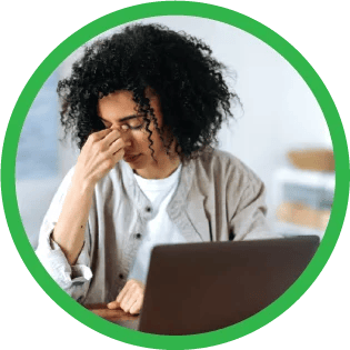 A tutor looking stressed while looking at laptop.