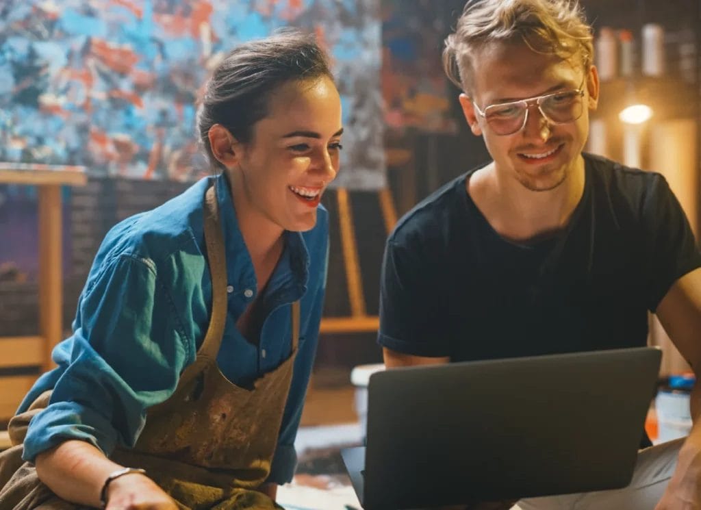Two artists working together on a laptop