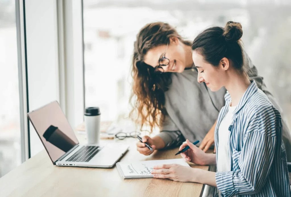 Tutor and college student work on an assignment at a desk in a learning center.