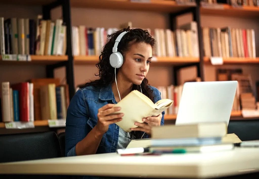 Student studying course material in library