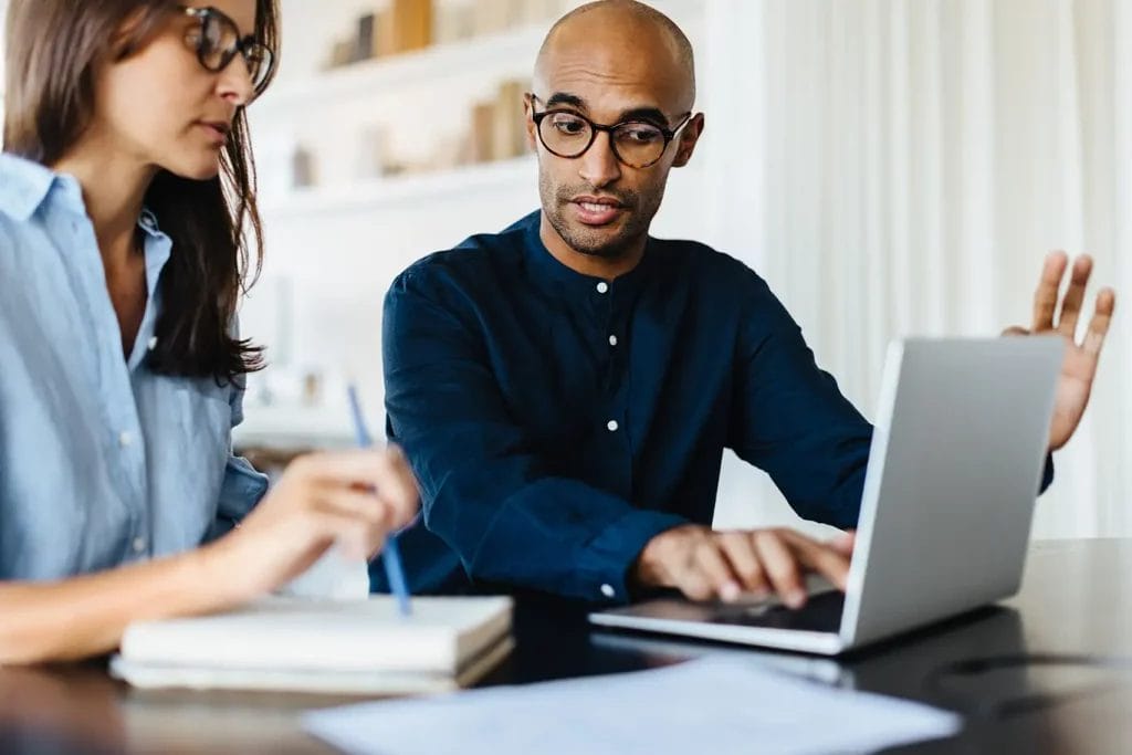 Life coach sitting with client setting goals and making plans.