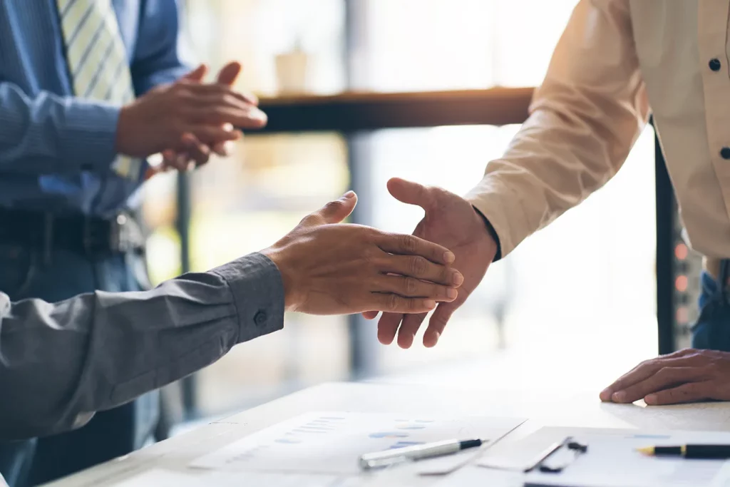 Two people about to shake hands representing forming new client relationships