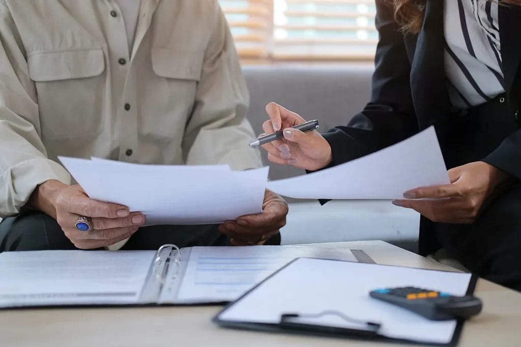 Two people seated by some paperwork