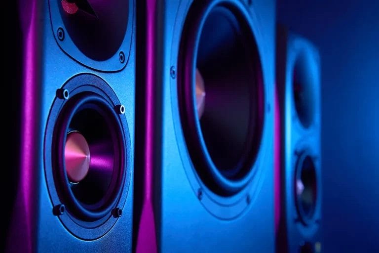 Close up look at DJ equipment speaker with blue and purple reflective lights