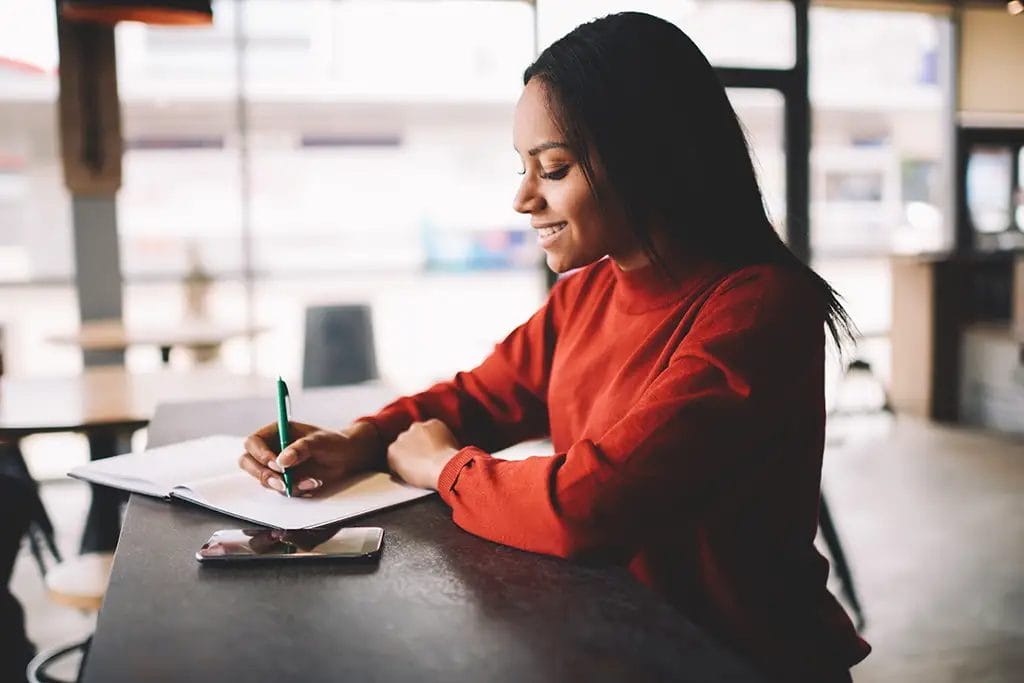 Person reflecting on the goals they set in a notebook