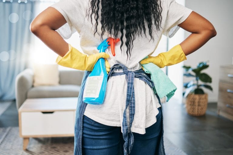 woman with hands on hips admiring room she just cleaned