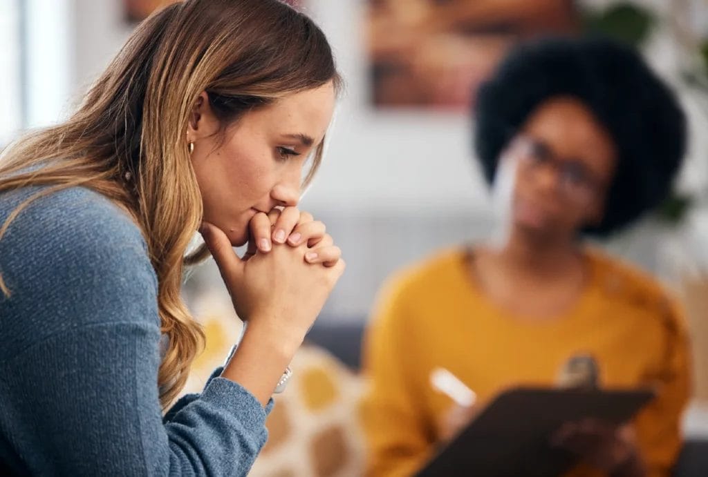Troubled client talks to life coach with a clipboard