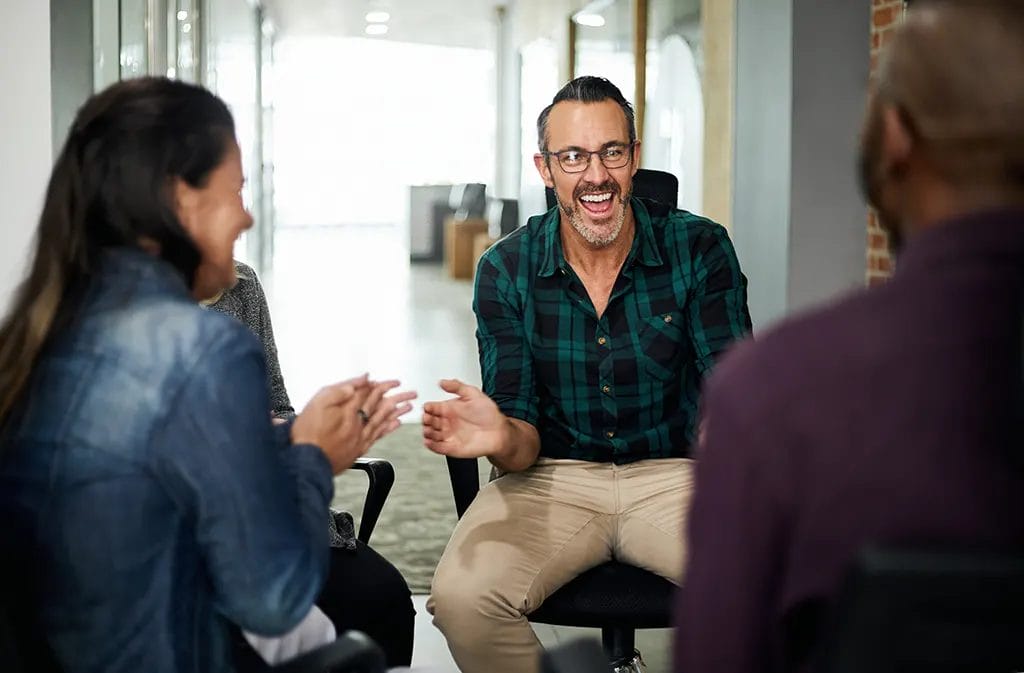 Group of people talking in a circle with focus on one individual.